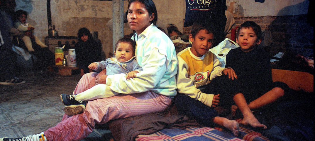 Una mujer con sus tres hijos en un centro de evacuados en la inundación de santa fe