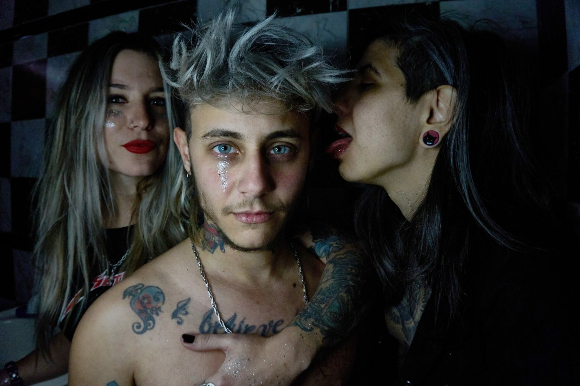 Una fotografía promocional de cuerpo completo y al aire libre de los tres miembros de la banda 